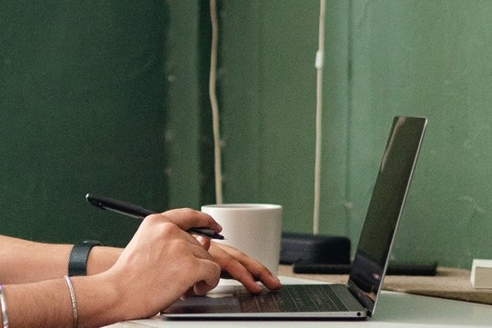 close-up of person's hands typing on a laptop