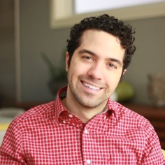 Emmanuel smiling, wearing a red shirt